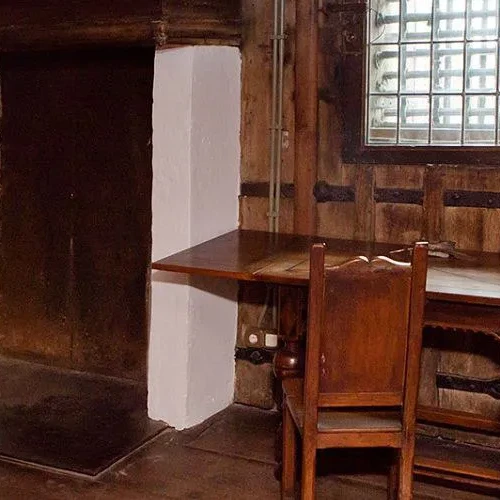 Historische gevangeniskamer met schilderijen en martelwerktuigen.