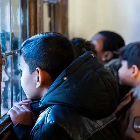 Kinderen luisteren naar een rondleiding in het museum De Gevangenpoort.